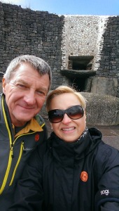 Louise and Michael visiting Ireland, standing in front of the ancient tomb at New Grange.
